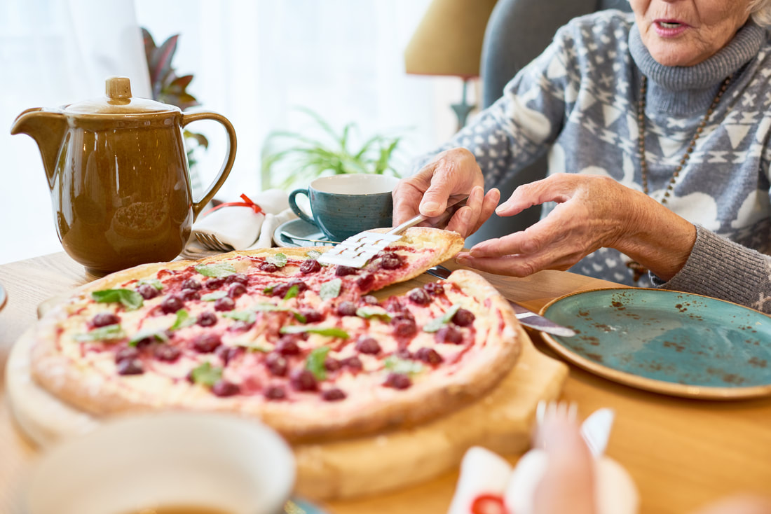 elderly woman eating pizza